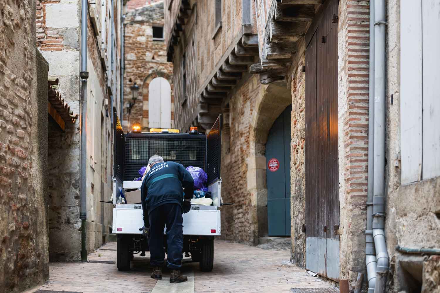 G4 assurant la collecte de déchets dans une ruelle